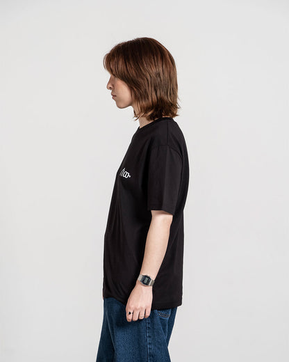 Schwarzes T-Shirt mit weißem Brustlogo, seitlich getragen gezeigt.